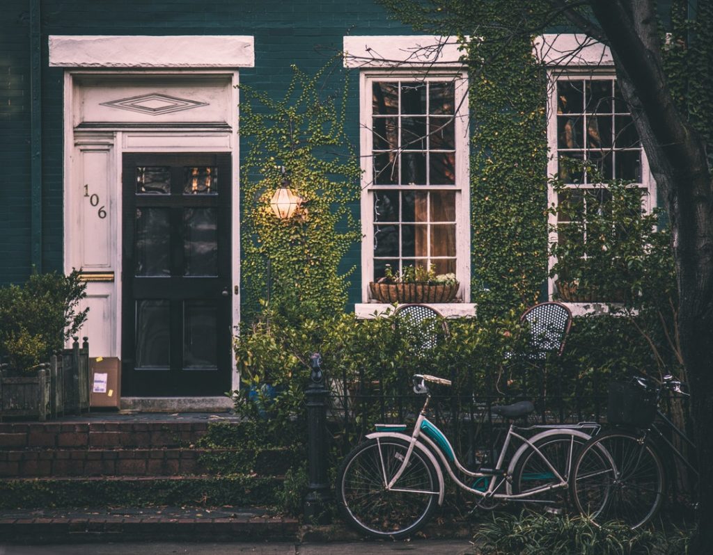 exterior of house with vines growing on it and bike sitting outside