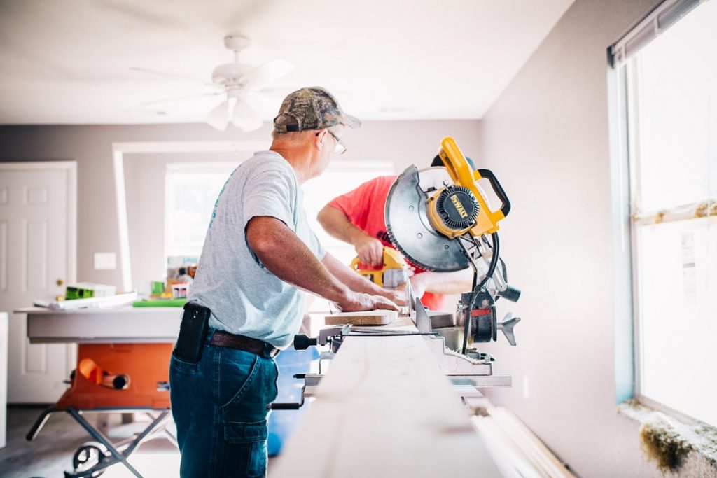 Man using saw to cut wood for renovations