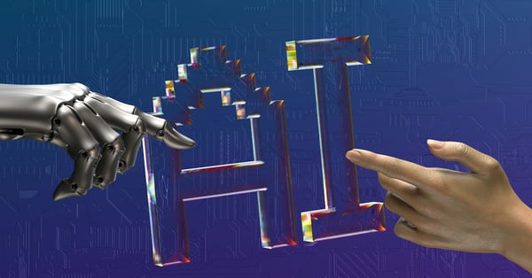 Robot hand and human hand reaching toward AI letters