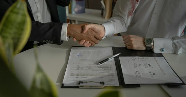 Buyer and agent shaking hands over a property contract
